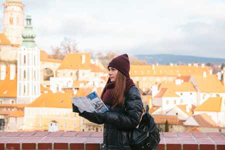 A tourist looks at a map while traveling to Cesky Krumlov in the Czech Republic in the winter.の写真素材