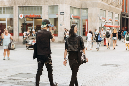 Germany, Leipzig, September 6, 2018: Young couple punks or friends walking down the street in Leipzig. He listens to music on the phone. Youth subculture.のeditorial素材