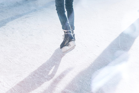 A person skates on a skating rink or on the ice rink during the Christmas holidays on a sunny winter day. Fun pastime.の写真素材