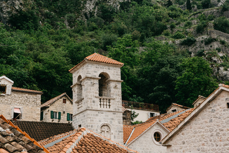 Beautiful view of the bell tower of the Orthodox Church in Kotor in Montenegro. Religious building. In the background is a mountain with trees.の写真素材
