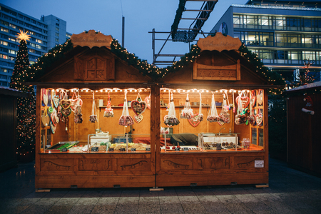Berlin, December 25, 2017: Selling sweets and traditional gingerbread in the evening at the Christmas market in Berlin. Decorated stall.のeditorial素材