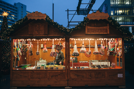Berlin, December 25, 2017: Selling sweets and traditional gingerbread in the evening at the Christmas market in Berlin. Decorated stall.のeditorial素材