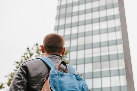 A tourist with a backpack or a guy arrived to check into apartments or watch sights in a big city or...
