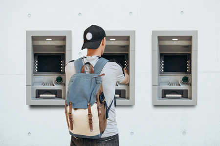 The tourist withdraws money from the ATM for further travel. Finance, credit card, withdrawal of money. Life style. Grabs a card from the ATM.の写真素材