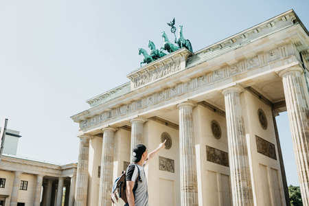 Tourist or guy shows his hand on the Brandenburg Gate in Berlin in Germany.の写真素材