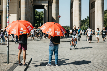Germany, Berlin, September 05, 2018: Guides with red umbrellas are waiting for tourists on the...