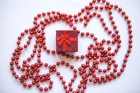 Red box with a gift. Concept for Valentines Day or Womens Day or another holiday in a minimal style.の写真素材
