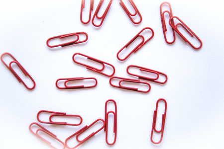 Closeup of red paper clips on a white background lie abstract.の写真素材