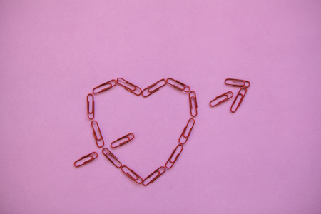 Clips lined in the shape of a heart. Valentines Day celebration concept in minimal style.