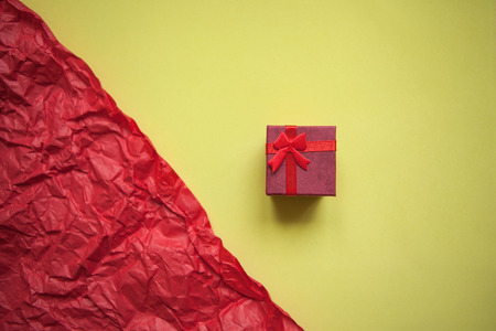 Red box with a gift on a yellow and red background. Concept for Valentines Day or Womens Day or another love event in minimal style.の写真素材