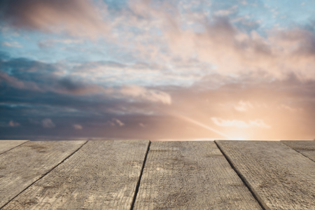 Wooden board or table or surface or floor against the sunset sky - can be used to montage or showcase your products.の写真素材