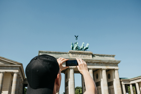 Tourist photographs on a mobile phone the Brandenburg Gate in Berlin in Germany. Sightseeing.の写真素材