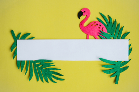 Summer design. Flamingo with tropical leaves on a yellow background. In the middle is a space for text.の写真素材
