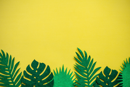 Tropical leaves in a row on a yellow background. Summer minimalistic design. Above there is a place for text.の写真素材