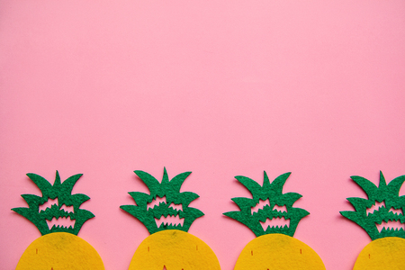 Pineapples in a row on a pink background. Summer minimalistic design. Above there is a place for text.の写真素材