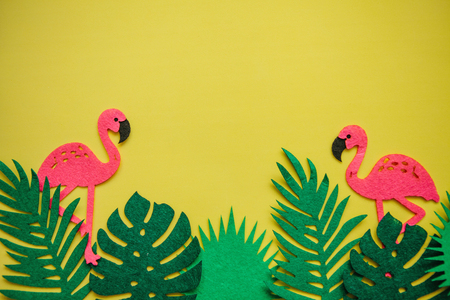 Flamingos and leaves on a yellow background. Summer design. Above there is a place for text.の写真素材