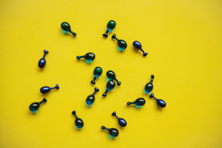 Fillers or capsules with hyaluronic acid on a yellow background. Skin care and facial health.の写真素材