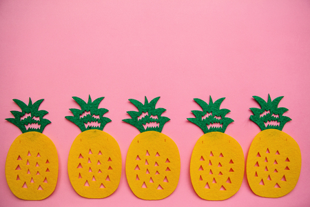 Pineapples in a row on a pink background. Summer minimalistic design. Above there is a place for text.の写真素材