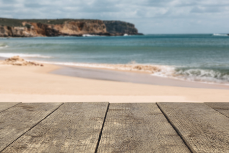Wooden board or table or surface or floor in the background of the sea or ocean off the coast or beach - can be used to montage or showcase your products.の写真素材