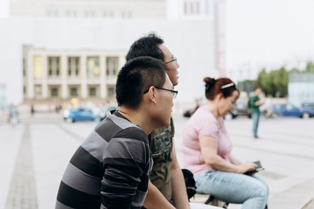 Germany, Leipzig, September 6, 2018: Asian tourists or immigrants sit in the city park and admire the sights.のeditorial素材