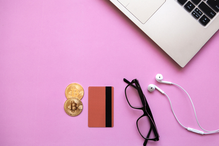 Conceptual photo of e-commerce with credit cards and cryptocurrency. Computer, cryptocurrency and credit card on a trendy pink background.の写真素材
