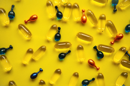 Capsule background with Omega 3, hyaluronic acid and coenzyme. Caring for the health of the skin and body.の写真素材