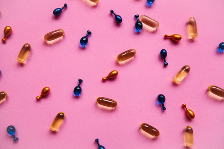 Capsule background with Omega 3, hyaluronic acid and coenzyme. Caring for the health of the skin and body.の写真素材
