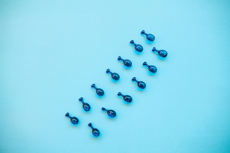 Fillers or capsules with hyaluronic acid on a blue background. Skin care and facial health.の写真素材