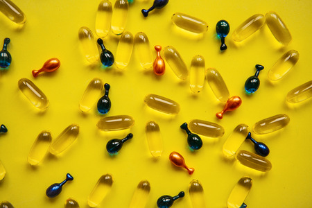 Capsule background with Omega 3, hyaluronic acid and coenzyme. Caring for the health of the skin and body.の写真素材