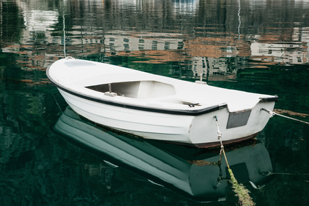 White empty fishing wooden boat in the sea near the shore.の写真素材