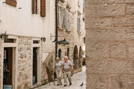 Montenegro, Kotor, June 27, 2018: An elderly couple of tourists visiting the sights of the Old Town in Kotor in Montenegro.のeditorial素材