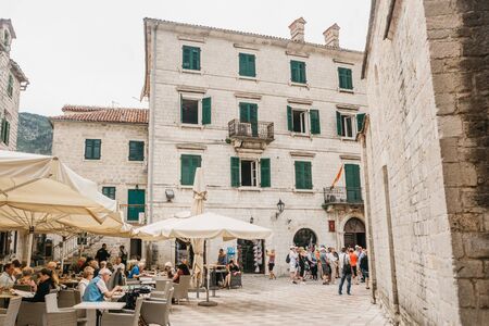 Montenegro, Kotor, June 27, 2018: Tourists relax in a street cafe in the Old Town, others watch the sights.のeditorial素材