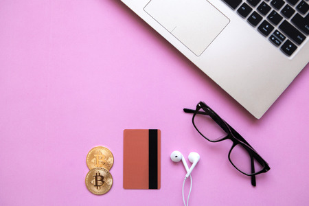 Conceptual photo of e-commerce with credit cards and cryptocurrency. Computer, cryptocurrency and credit card on a trendy pink background.の写真素材