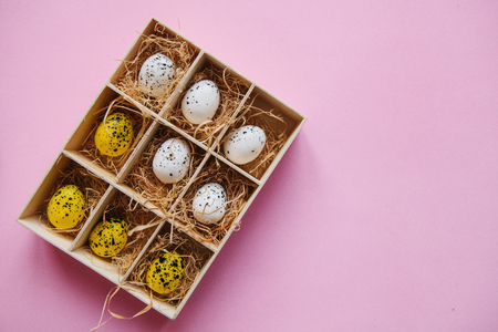 A set of eggs in a box or container on a pink background. Festive Easter concept in minimal style. Nearby there is a place for text.の写真素材