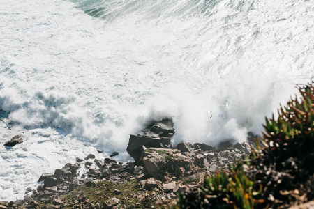 Wave and foam in the sea or ocean near the shore close-up. Beautiful nature.の写真素材