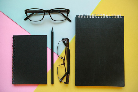 Glasses, notebook and pencil on a colorful background.の写真素材