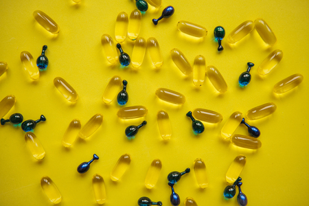 Capsule background with Omega 3, hyaluronic acid. Caring for the health of the skin and body.の写真素材