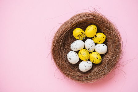 Many colored traditional Easter eggs on a pink background. Easter celebration background.の写真素材