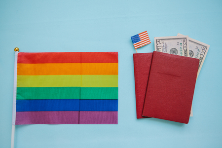 The multi-colored flag is a rainbow-colored or LGBT flag next to a passport. LGBT migration.の写真素材