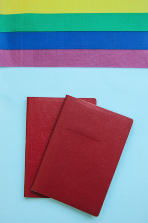 The multi-colored flag is a rainbow-colored or LGBT flag next to a passport. LGBT migration.の写真素材