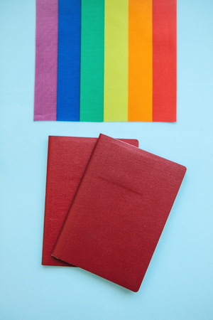 The multi-colored flag is a rainbow-colored or LGBT flag next to a passport. LGBT migration.の写真素材