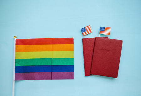 The multi-colored flag is a rainbow-colored or LGBT flag next to a passport. LGBT migration.の写真素材
