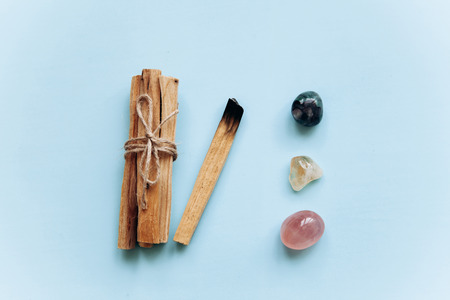 A set of wooden sticks Palo Santo on a blue background. Nearby are special stones - minerals. They are used in religious ceremonies.の写真素材