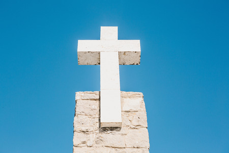 A beautiful view of the Christian Cross at Cape Roca in Sintra in Portugal against the background of a blue sky.の写真素材