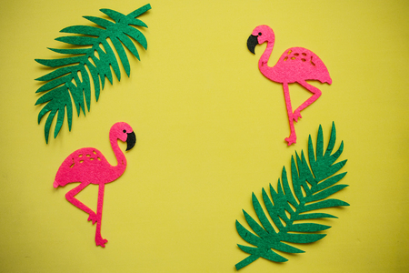 Flamingos and leaves on a yellow background. Summer design. In the middle there is a place for text.の写真素材