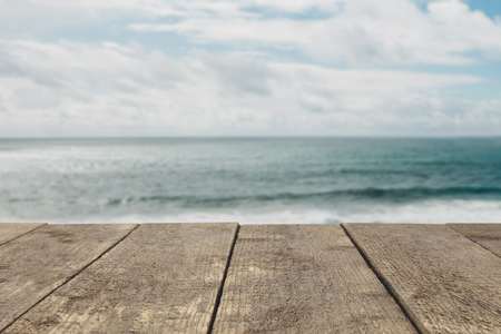 Wooden board or table or surface or floor against the background of the sea or ocean - can be used to montage or showcase your products.の写真素材