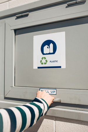 A person opens or closes a modern waste bin for separate collection of waste.の写真素材