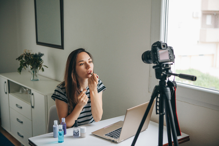 A beauty blogger or video blogger tells and shows subscribers how to do makeup.の写真素材