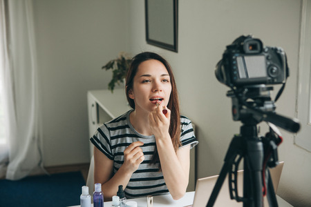 A beauty blogger or video blogger tells and shows subscribers how to do makeup.の写真素材