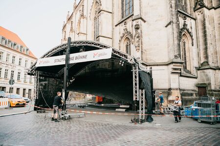 Germany, Muenster, August 17 2018: Workers construct a stage for a concert in the central square. Preparation for the city festival.のeditorial素材